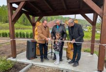 Un groupe de personnes s'apprête à coupe rle ruban lors d'une inauguration.
