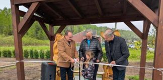 Un groupe de personnes s'apprête à coupe rle ruban lors d'une inauguration.