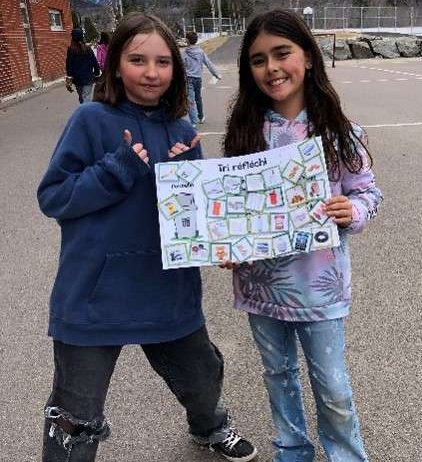 Deux jeunes filles nous montrent une pancarte sur le tri sélectif