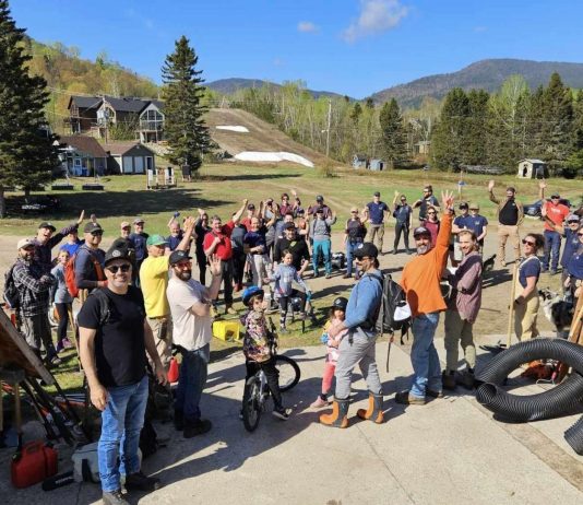 un groupe de bénévoles heureux au pied de la montagne du Mont-Édouars à L'Anse-Saint-Jean