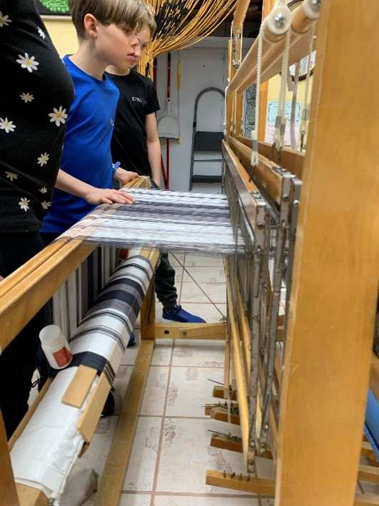 Un jeune devant un métier à tisser