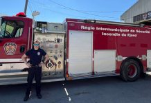 Un pompier pose fièrement devant le camion de l RISIF à Sant-Félix-d'Otis