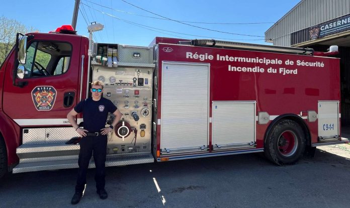 Un pompier pose fièrement devant le camion de l RISIF à Sant-Félix-d'Otis