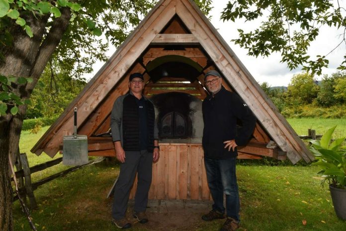 deux hommes entourent un four à pain