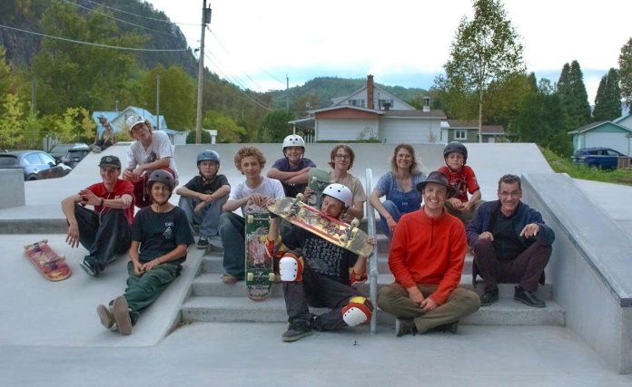 Philome La France, Marc Grandbois, Juliette Charpentier et jeunes skateurs Un groupe de gens assis sur les marches du tout nouveau skate park de Petit-Saguenay.