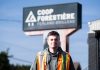 Un jeune homme pose devant la Coop forestière de ferland-et-Boilleau