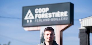 Un jeune homme pose devant la Coop forestière de ferland-et-Boilleau