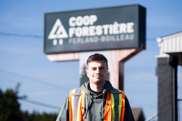 Un jeune homme pose devant la Coop forestière de ferland-et-Boilleau