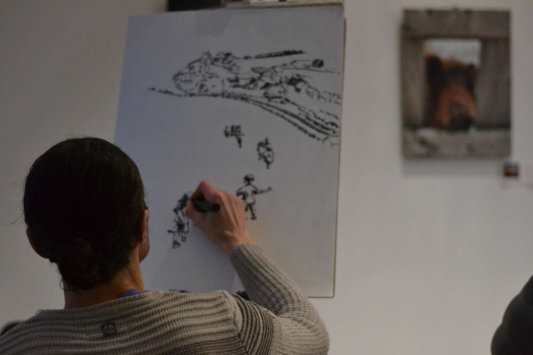 Un homme de dos dessine au tableau