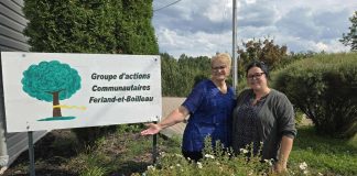 Deux femmes prennent la pause devant la pancarte de leur organisme