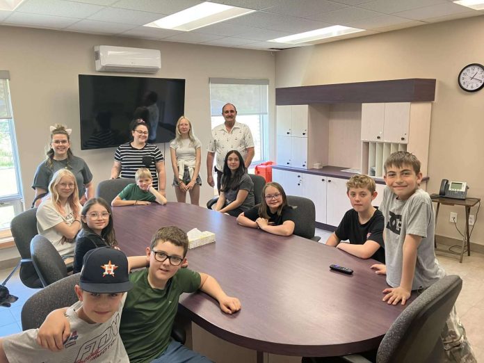 Un groupe de jeunes élèves dans la salle municipale de leur village