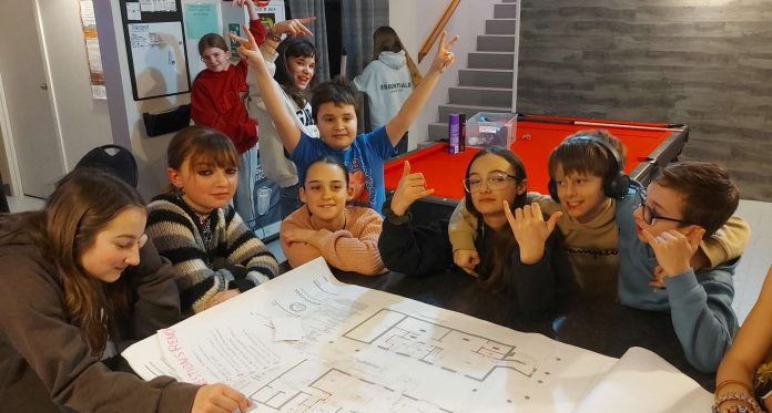 Des jeunes autour d'une table dessinent leur projet de local