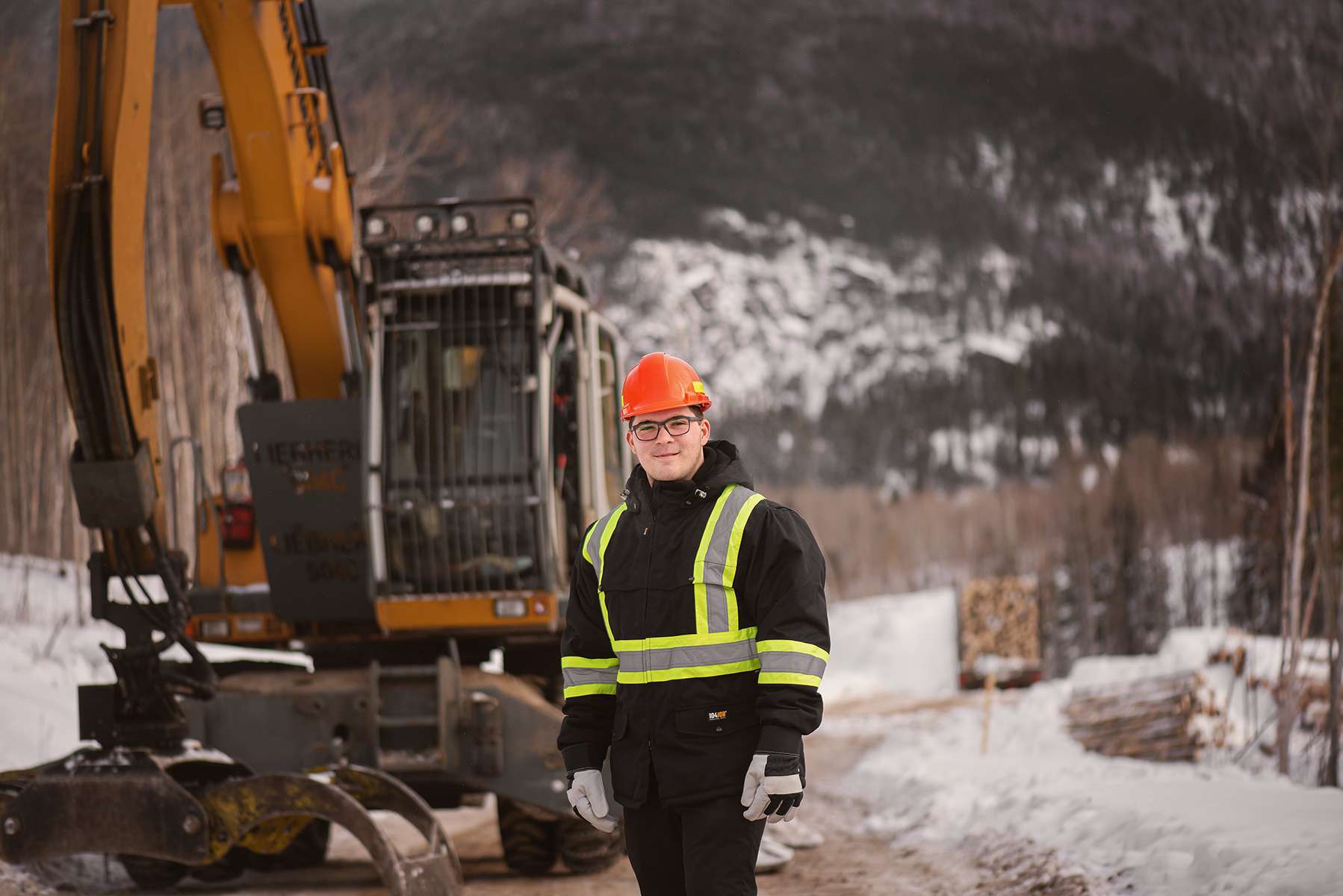 Travailleur forestier devant une grosse multifonctionnelle