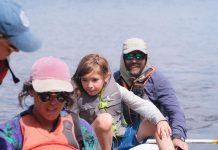 deux adultes et une enfant débarquent d'un canot
