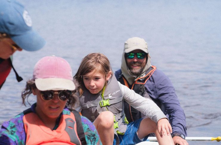 deux adultes et une enfant débarquent d'un canot